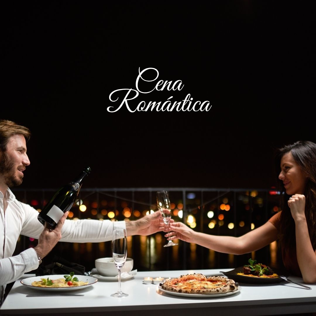 Pareja brindando con champán en una cena romántica a domicilio en Bogotá, con pasta, pizza artesanal y vista nocturna de la ciudad