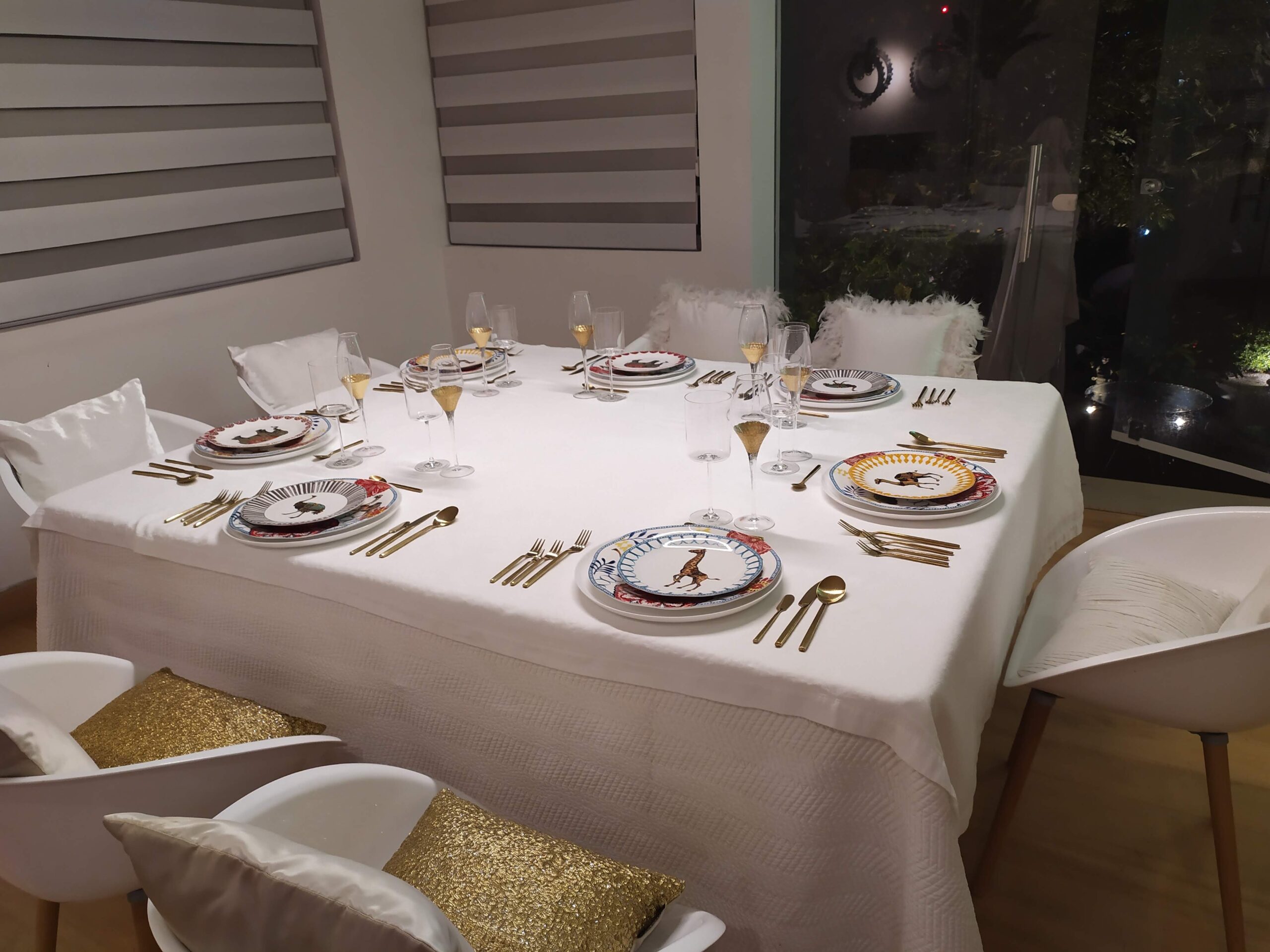 Mesa elegante con vajilla de diseño, copas de champán y cubiertos dorados, montada por nuestro servicio de chef privado a domicilio en Bogotá